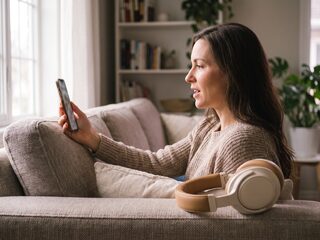 A shopper on a sofa recording a video review on her phone.